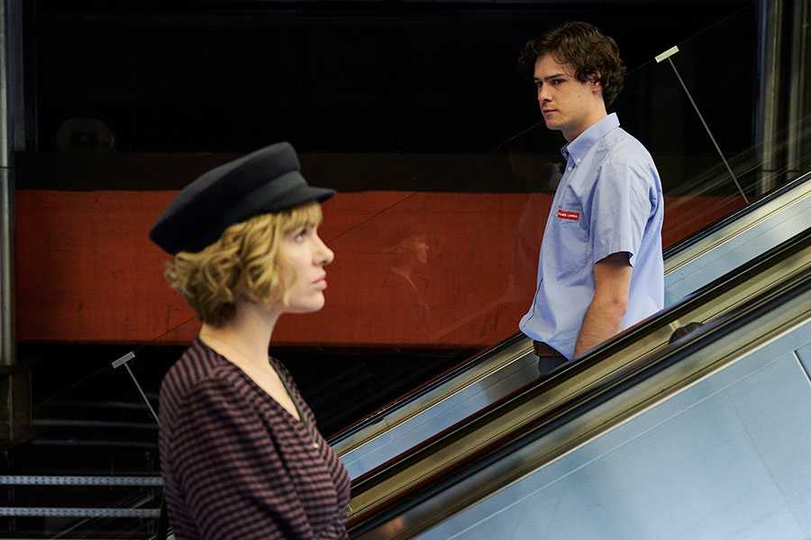 A scene from the German film 'Sterne unter der Stadt' showing Verena Altenberger with blonde hair and a cap in a subway station.