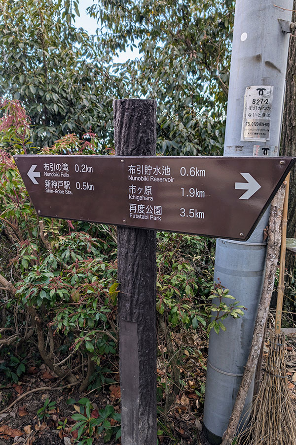 Trail sign near Shin-Kobe Station showing hiking distances to Nunobiki Falls, Nunobiki Reservoir, and Futatabi Park