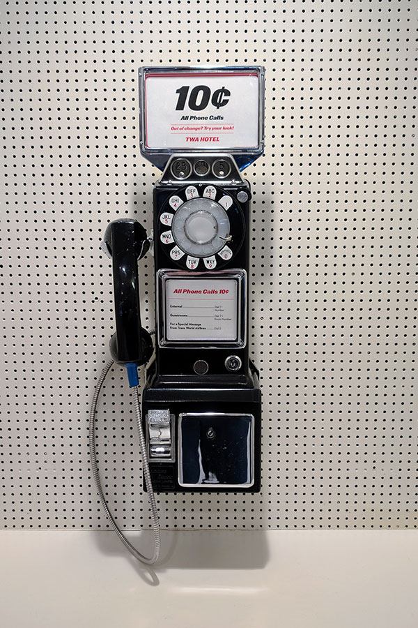 Close-up of a classic payphone at the TWA Hotel, showcasing its ten-cent call signage and mid-century design.