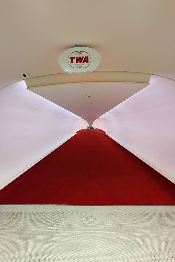The distinctive hallway design of the TWA Hotel, characterized by its red carpet and minimalist aesthetic