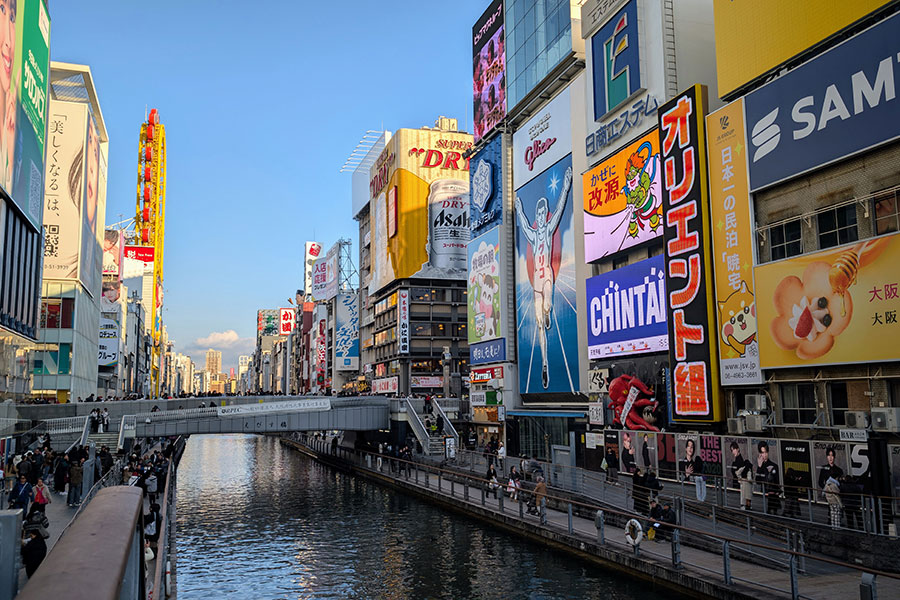Dotonbori Canal in Osaka with colorful billboards and the Glico running man sign on a winter afternoon