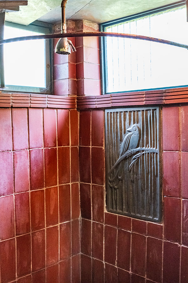 Artistic bathroom in the Wharton Esherick House with red tiles and a hand-carved bird panel
