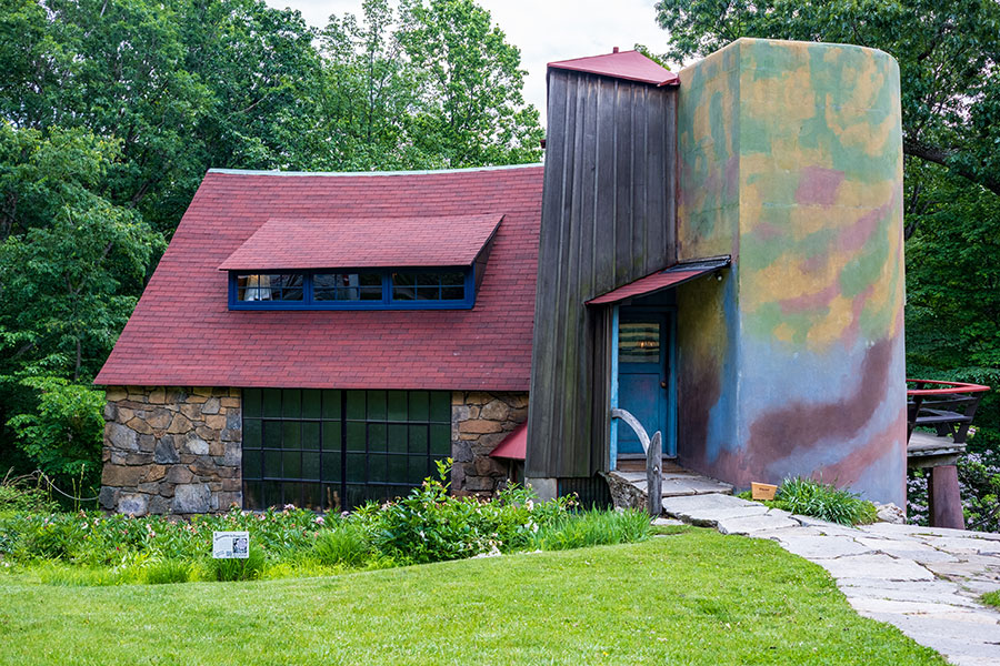 Exterior view of the Wharton Esherick Museum and Studio, featuring stone walls, red roof, and colorful silo in Malvern, Pennsylvania.