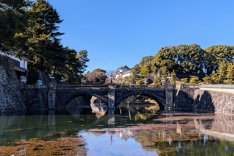 A symmetrical view of the elegant stone arches of the Seimon Ishibashi, popularly known as Nijubashi Bridge, at the Tokyo Imperial Palace.