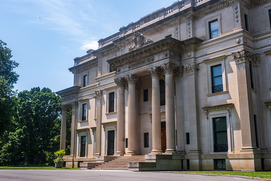 The grand Beaux-Arts stone facade and towering entrance columns of the Vanderbilt Mansion National Historic Site in Hyde Park, NY.