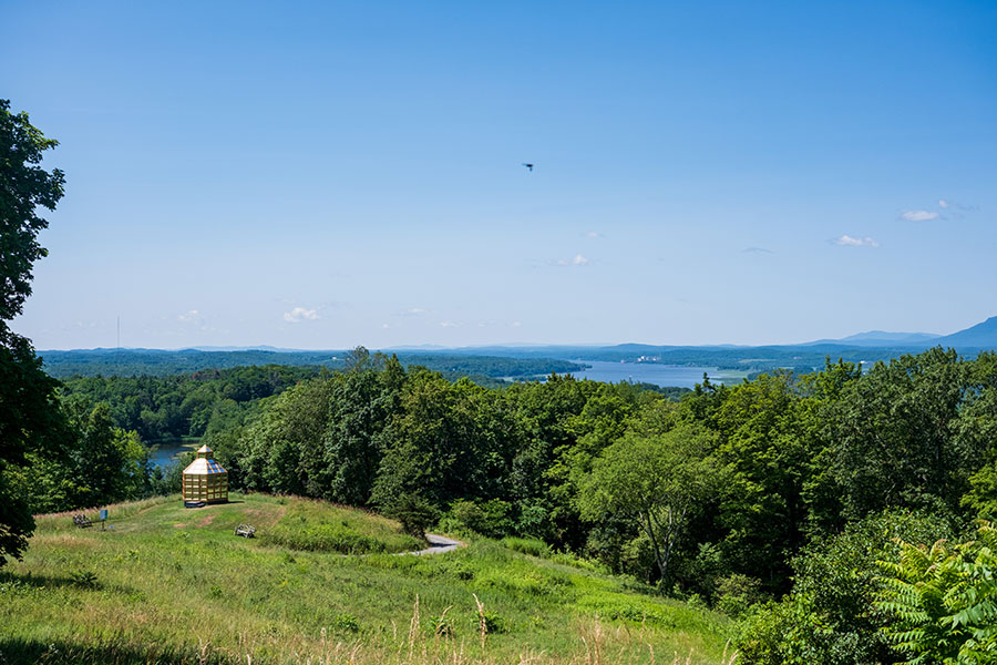 Panoramic view from Olana State Historic Site overlooking the Hudson River and Catskill Mountains, with a golden folly in the foreground.