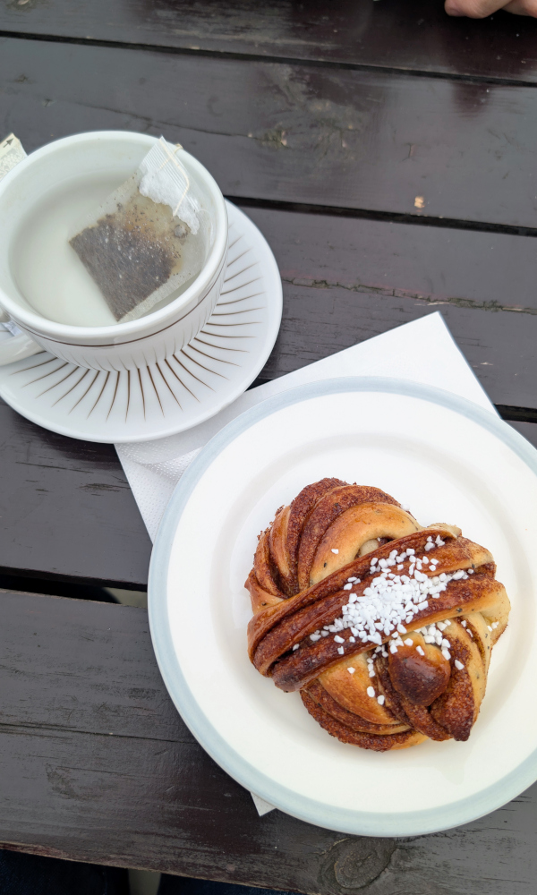 Swedish cinnamon bun (kanelbullar) with pearl sugar topping served at a café during a traditional fika in Stockholm.