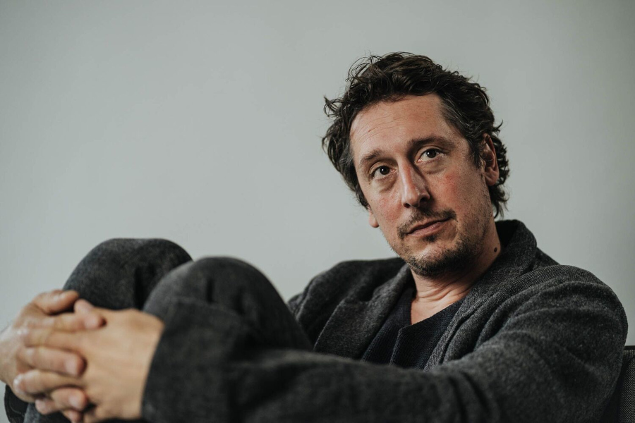 German actor Hans Löw, known for the film "In My Room," in a thoughtful pose for a German cinema and language learning blog post.